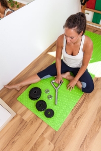 Fitness-Instructor Bernadette Hörner demonstriert eine Kettlebellstange inklusive Gewichtscheiben zum aufschrauben
