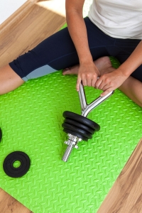 Fitness-Instructor Bernadette Hörner zeigt, wie man Hantelscheiben auf die Kettlebell-Stange schraubt