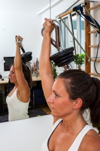 Fitness-Instructor Bernadette Hörner demonstriert die Übung "Press" mit Kettlebell-Hantelstange