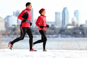 Frau und Mann joggen bei Schnee in einer Großstadt