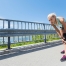 Läuferin pausiert Joggingrunde aufgrund von Knieschmerzen