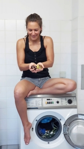 Fitnessbloggerin Bernadette Hörner sitzt auf Waschmaschine mit Kastanien in der Hand