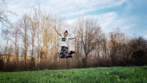 Fitnessbloggerin Bernadette Hörner springt im T-Shirt Winter auf einer Wiese (Erholungsgebiet Wien Simmering)